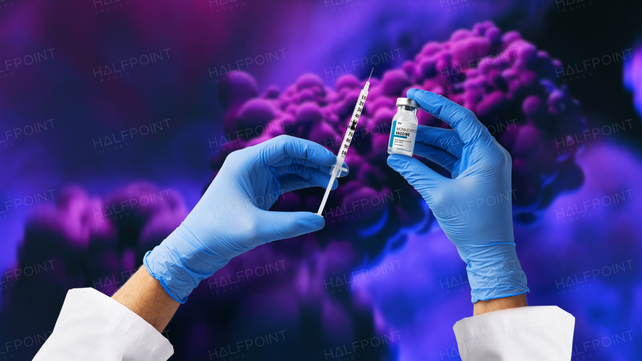 A doctor's hand holding monkeypox vaccine with microscopic view of floating monkeypox virus cells or molecules in background.