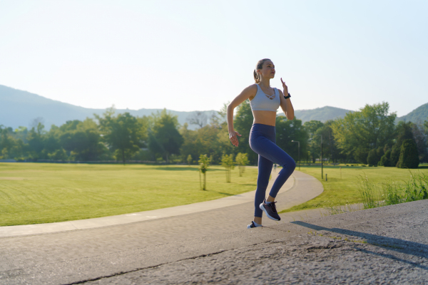 Sporty woman running on the concrete stairs in city park. Female athlete in sportswear doing stair workout outside. Healty lifestyle concept.