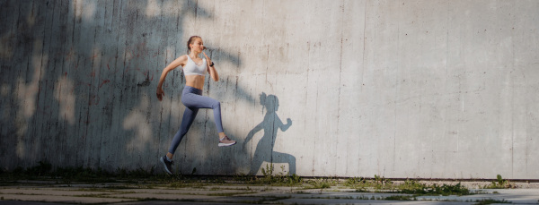 Beatutiful female athlete in sportswear exercising in the city wiht copy space.