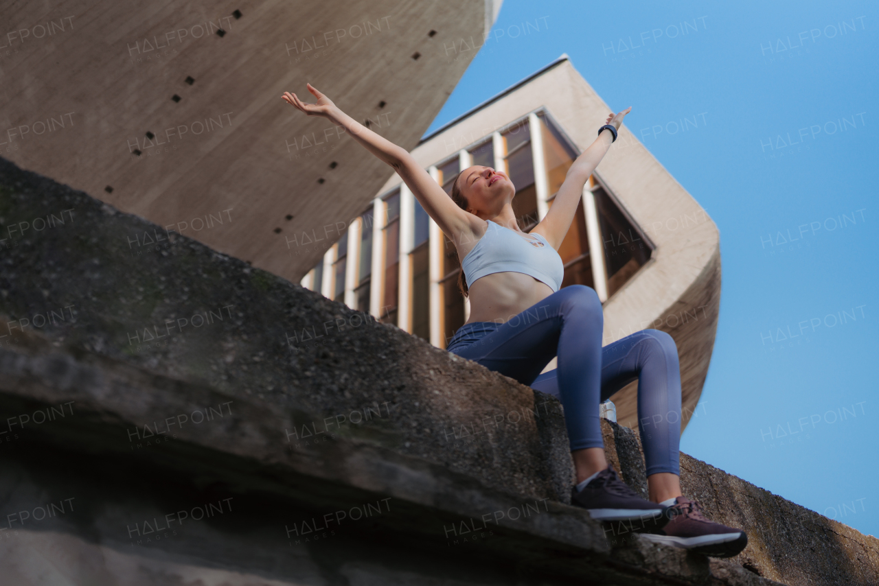 Happy fitness woman in sportswear enjoying feeling after workout session in the city. Beautiful sporty woman feeling good about yourself.