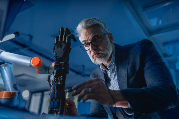 Robotics engineer adjusting, calibring robotic prosthetic artificial hand. Concept of modern technology in medicine. Robotic prosthetics, biomechatronics and neuroscience.