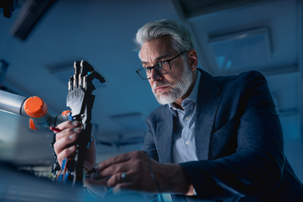 Robotics engineer adjusting, calibring robotic prosthetic artificial hand. Concept of modern technology in medicine. Robotic prosthetics, biomechatronics and neuroscience.