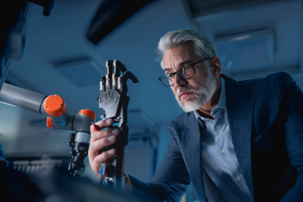 Robotics engineer adjusting, calibring robotic prosthetic artificial hand. Concept of modern technology in medicine. Robotic prosthetics, biomechatronics and neuroscience.