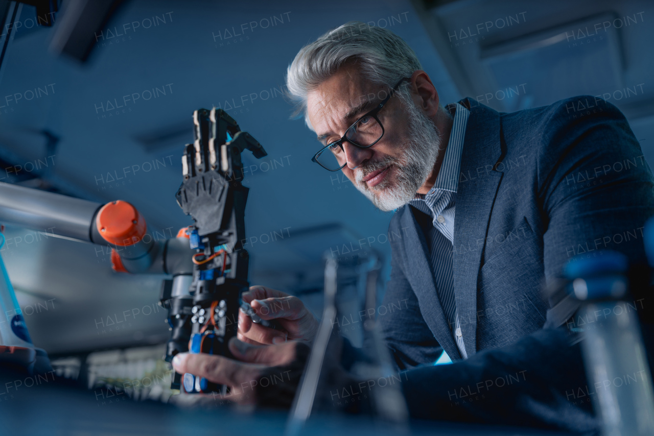 Robotics engineer adjusting, calibring robotic prosthetic artificial hand. Concept of modern technology in medicine. Robotic prosthetics, biomechatronics and neuroscience.