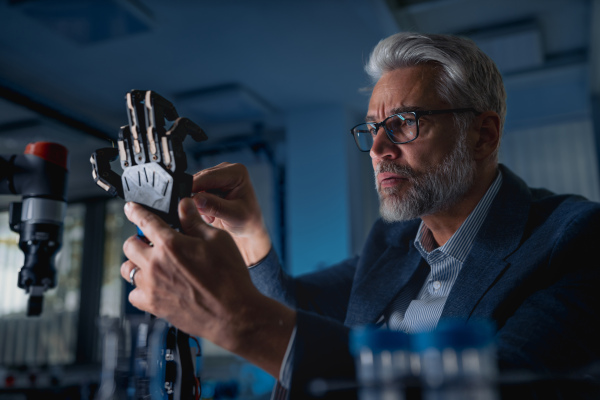 Robotics engineer adjusting, calibring robotic prosthetic artificial hand. Concept of modern technology in medicine. Robotic prosthetics, biomechatronics and neuroscience.