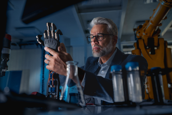 Robotics engineer adjusting, calibring robotic prosthetic artificial hand. Concept of modern technology in medicine. Robotic prosthetics, biomechatronics and neuroscience.