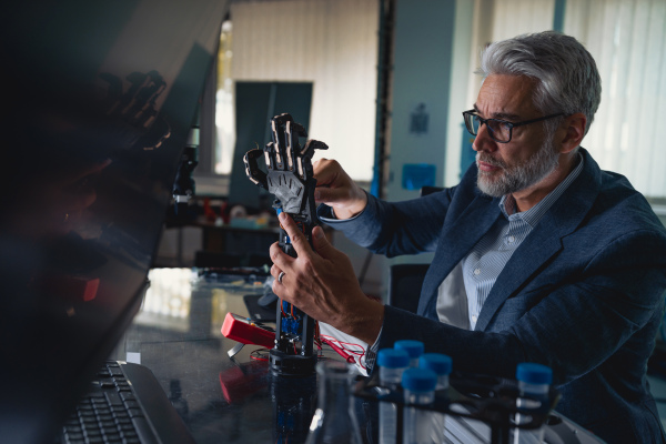 Robotics engineer adjusting, calibring robotic prosthetic artificial hand. Concept of modern technology in medicine. Robotic prosthetics, biomechatronics and neuroscience.