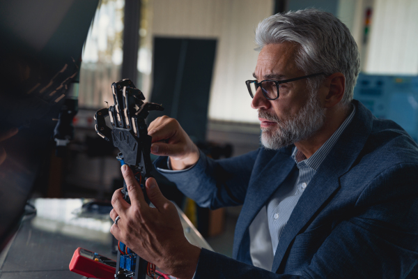 Robotics engineer adjusting, calibring robotic prosthetic artificial hand. Concept of modern technology in medicine. Robotic prosthetics, biomechatronics and neuroscience.