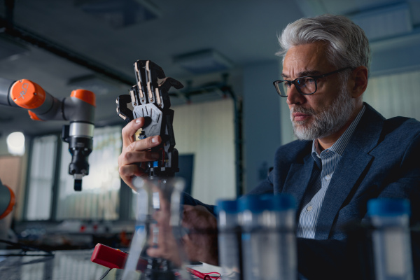 Robotics engineer adjusting, calibring robotic prosthetic artificial hand. Concept of modern technology in medicine. Robotic prosthetics, biomechatronics and neuroscience.