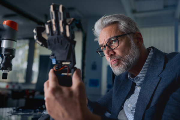 Robotics engineer adjusting, calibring robotic prosthetic artificial hand. Concept of modern technology in medicine. Robotic prosthetics, biomechatronics and neuroscience.