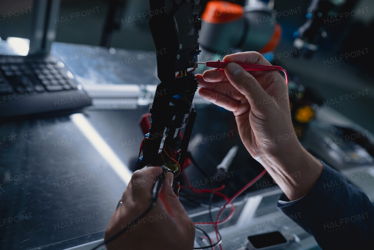 Close up on hands of engineer calibring robotic prosthetic hand. Concept of modern technology in medicine. Robotic prosthetics, biomechatronics and neuroscience.