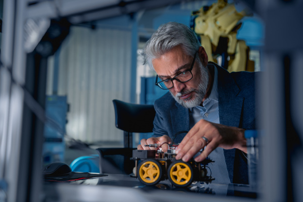 Automation, robotics engineer assembling robotic car. Concept of modern technology in industries, automated processes, automotive.