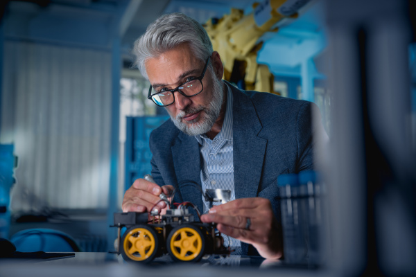 Automation, robotics engineer assembling robotic car. Concept of modern technology in industries, automated processes, automotive.