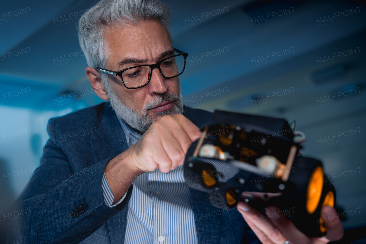 Automation, robotics engineer assembling robotic car. Concept of modern technology in industries, automated processes, automotive.