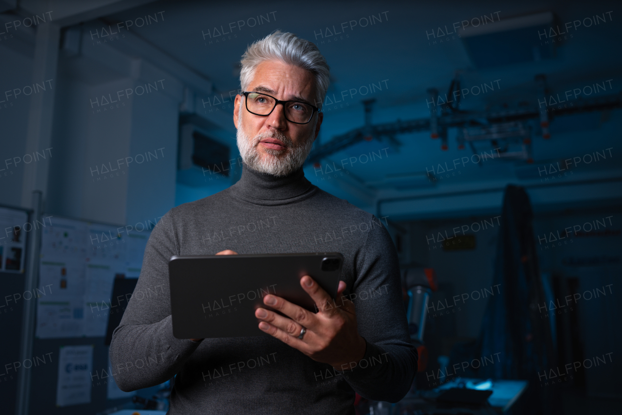 Automation engineer or robotics technician holding remote controller of robotic arm. Concept of modern technology in industries, automated processes and robotics.