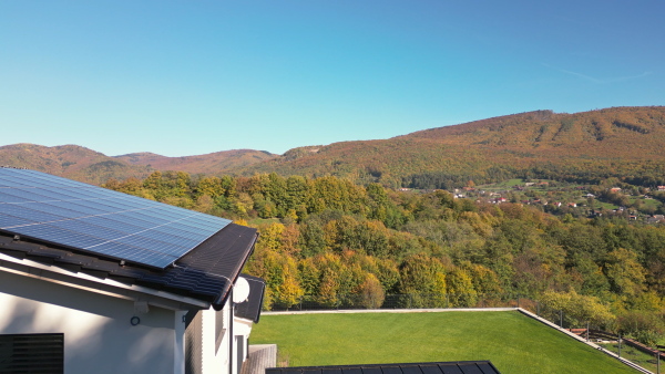 Photovoltaic panels on roof of eco house in nature. Drone shot.