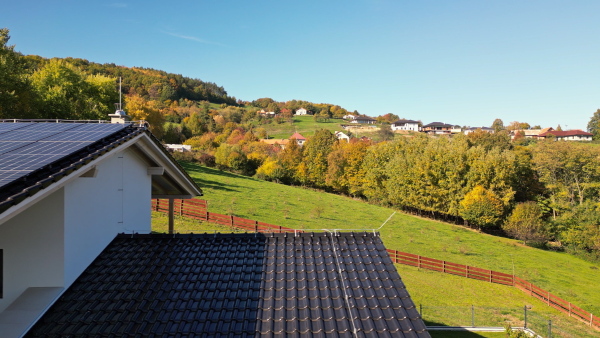 Solar panels on rooftop of modern sustainable home in beautiful nature environtment. Drone shot.