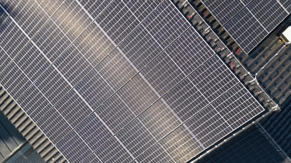 Solar panels on rooftop of modern sustainable home in beautiful nature environtment. Drone shot. Top view.