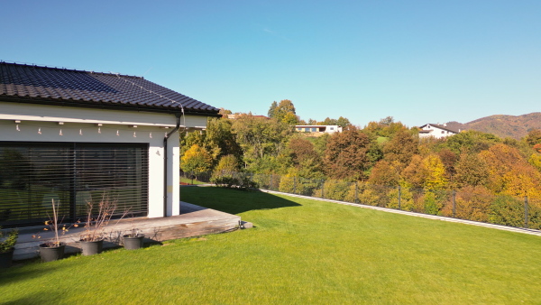 Eco house with photovoltaic panels on rooftop set in nature environment.