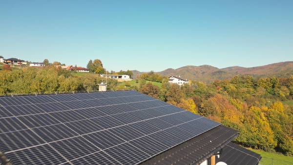 Solar panels on rooftop of modern sustainable home in beautiful nature environtment. Drone shot.