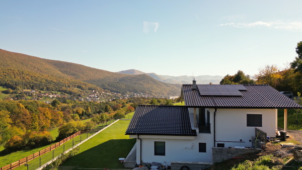 Photovoltaic panels on roof of eco house in nature. Drone shot.