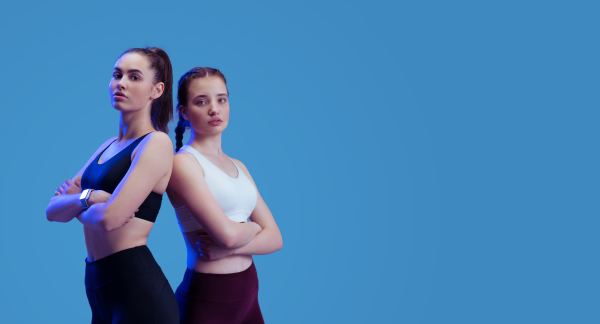 Young beautiful athlete women are posing in a studio, copy space.