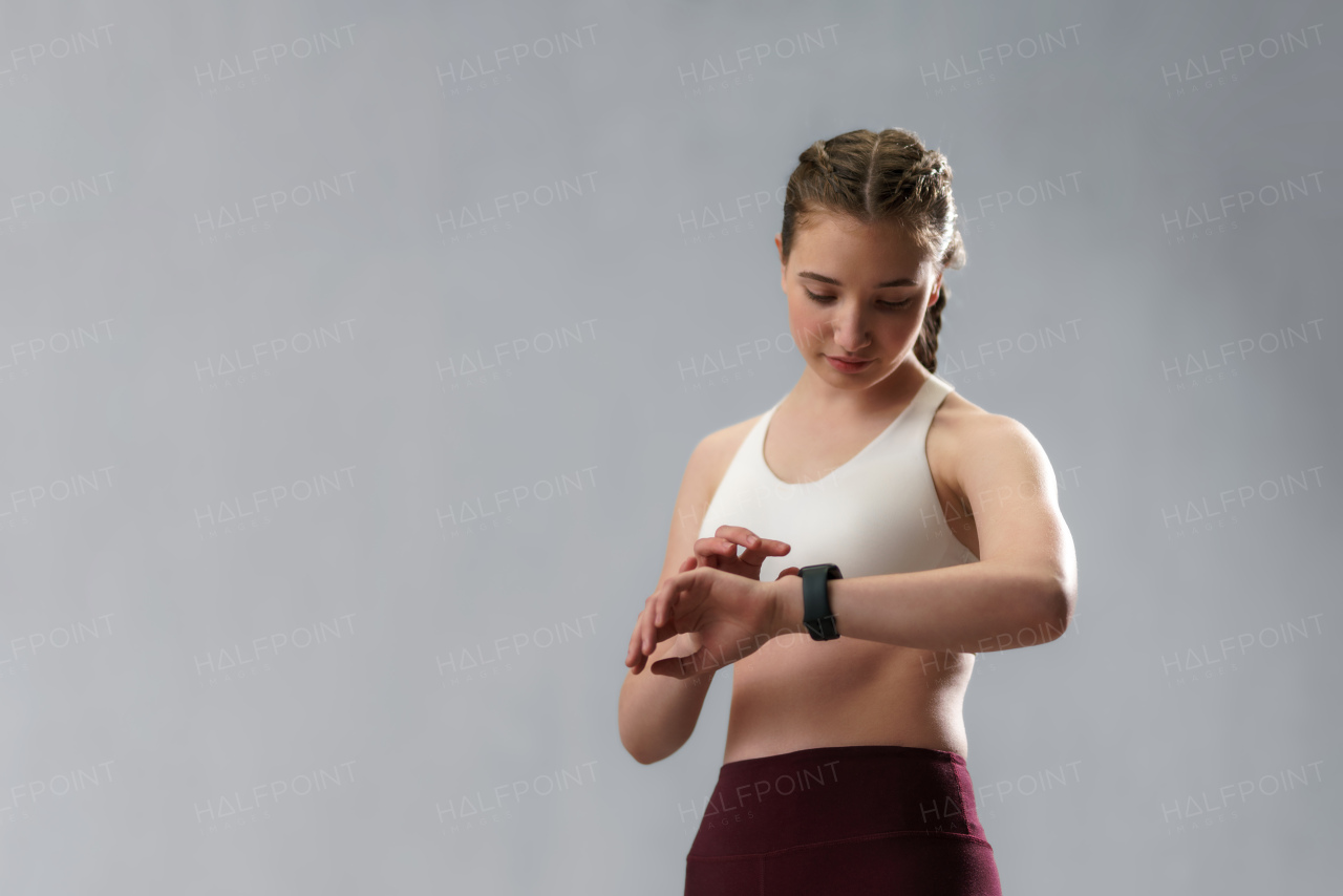 A close up shot of young woman setting and looking at sports smartwatch. Fitness female checking her performance.