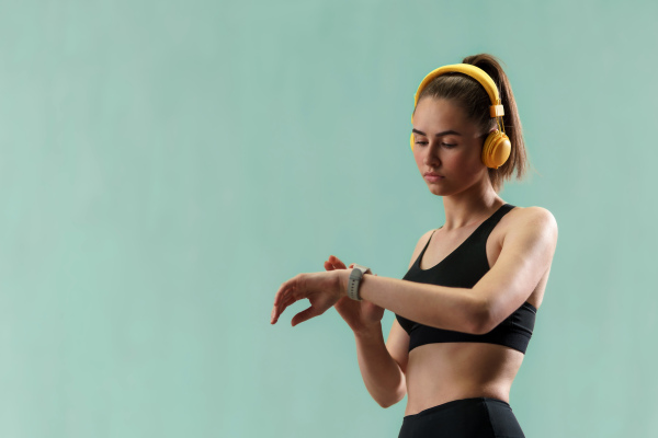 A close up shot of young woman setting and looking at sports smartwatch. Fitness female checking her performance.