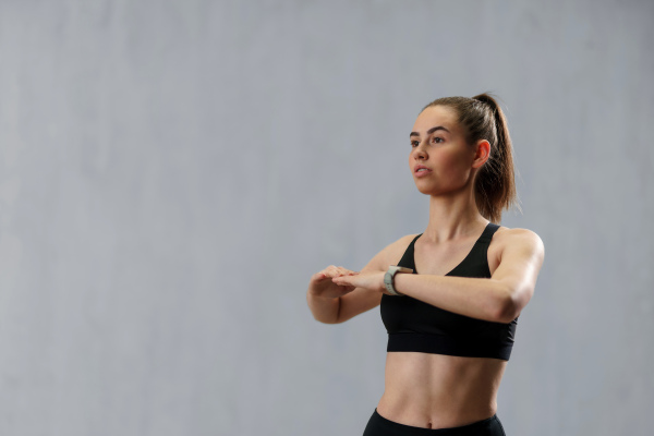 A close up shot of young woman setting and looking at sports smartwatch. Fitness female checking her performance.