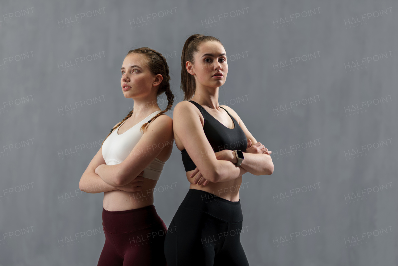 Young beautiful athlete women are posing in a studio, copy space.