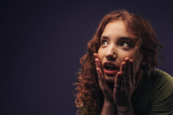 Portrait of a young surprised redhead woman, studio shoot.