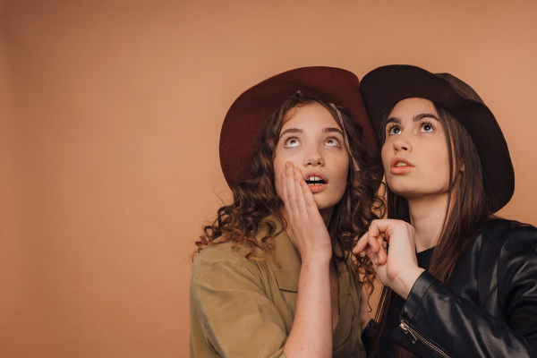 Portrait of two young surprised friends, studio shoot,