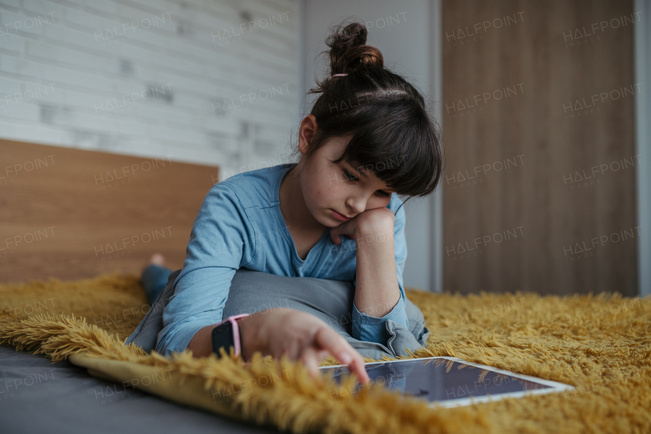 Young schoolgirl struggling with learning at home, doing homework. Learning difficulties in children.