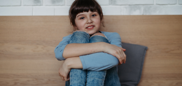 Portrait of a cute young girl. Girl with long hair sitting at home. Banner with copy space.