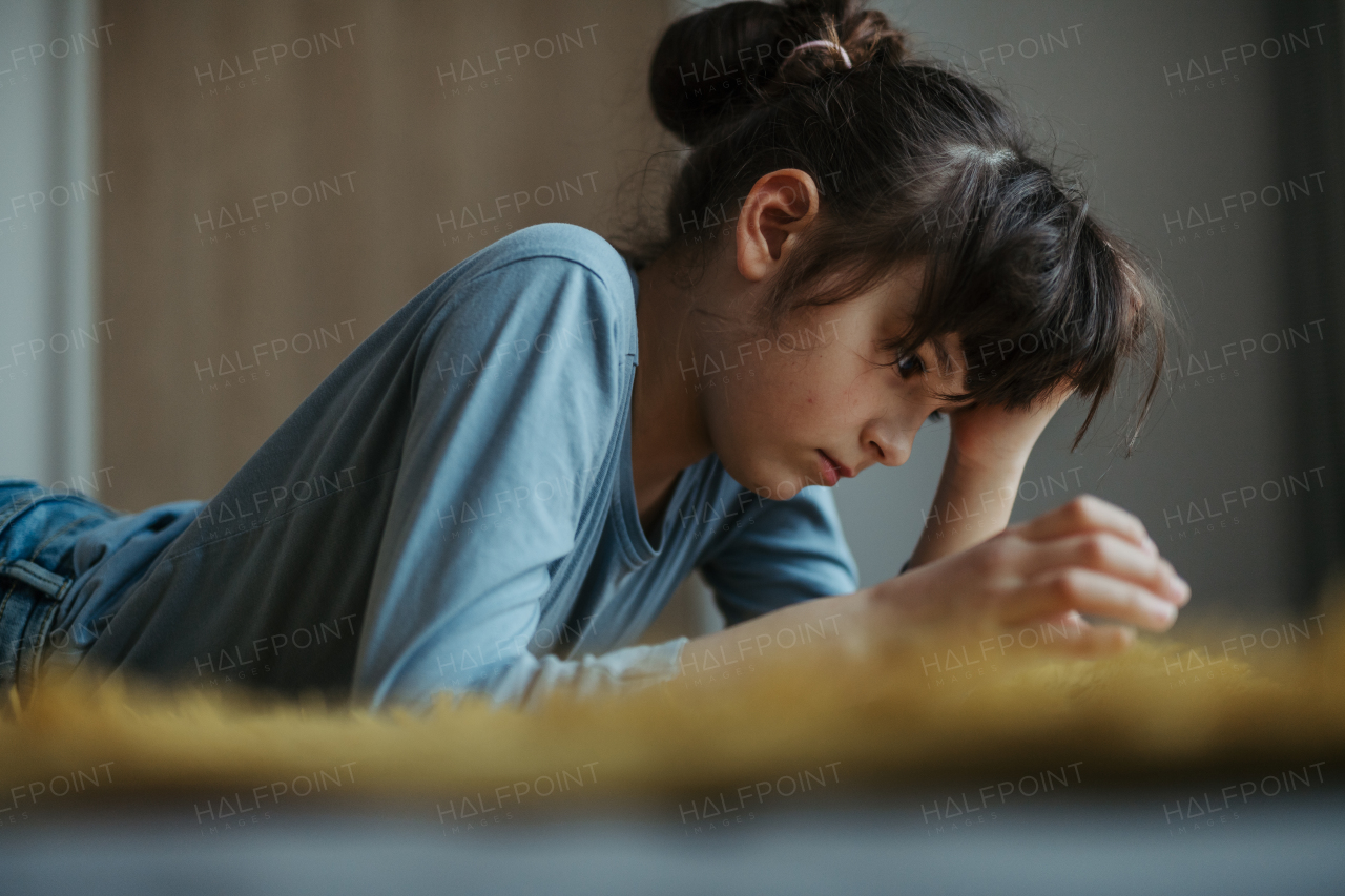 Young schoolgirl struggling with learning at home, doing homework. Learning difficulties in children.