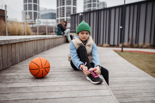 Girl in the city going to play basketball. Young girl spending a free time doing sport, enjoying after schoold outdoor activity.