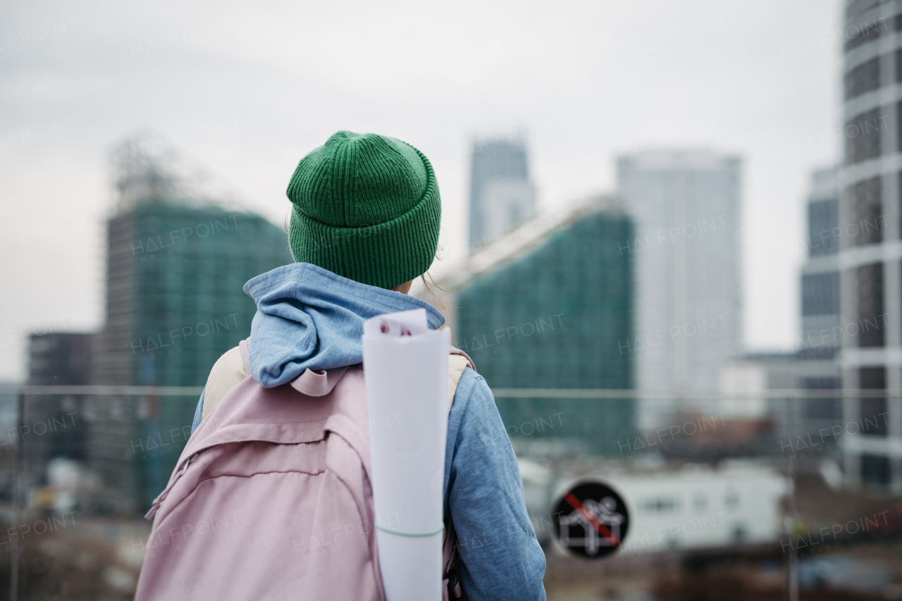 Sad girl alone, standing in city, waiting for parents. Young schoolgirl with no friends, feeling lonely. Mental health problems.