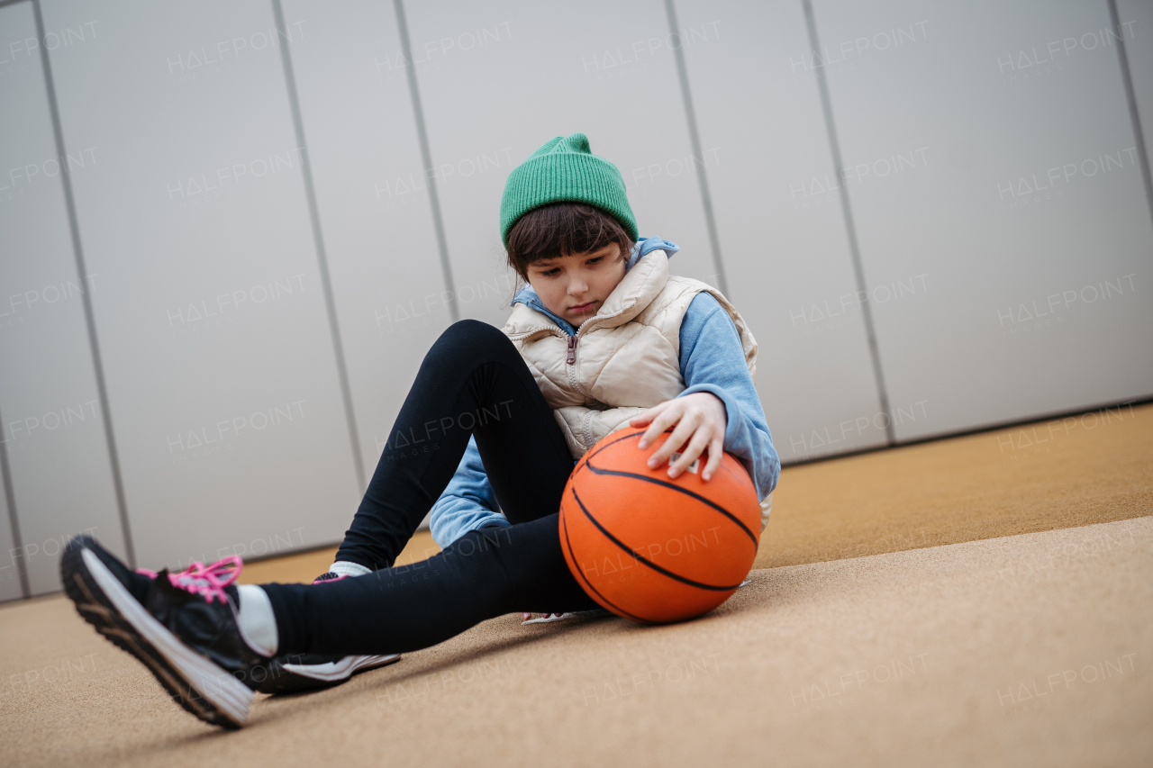 Sad girl alone in the city, want to play basketball. Young girl spending free time alone in the city, no friends. Mental health problems.