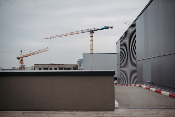 Construction site with buildings under construction with two cranes working, gray sky background. Crane during formworks.