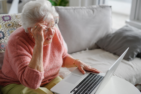 Senior woman learning to work with laptop, technology and internet, maintaining digital skills. Importance of digital literacy for elderly people.