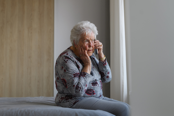 Senior woman making phone call, receiving bad news. Concept of loneliness and dependence of old people.