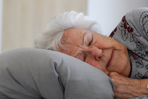 Senior woman sleeping in her bed alone, feeling anxious. Loneliness and social isolation of eldery woman.