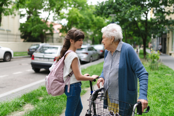 Grandmother explaining to granddaughter how to ride scooter safely before leaving for school.