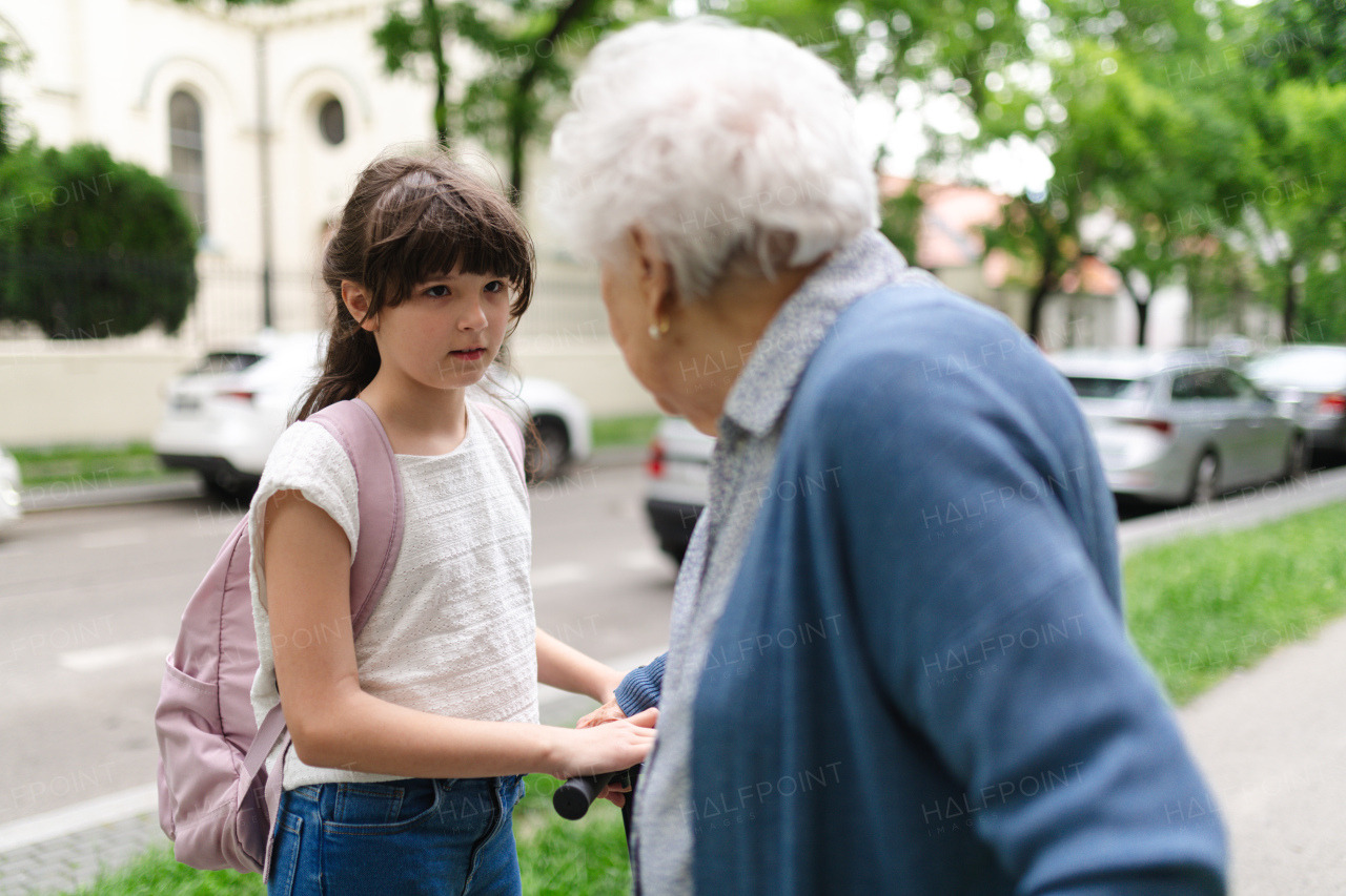 Grandmother explaining to granddaughter how to ride scooter safely before leaving for school.