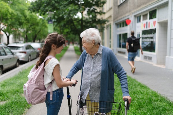 Grandmother explaining to granddaughter how to ride scooter safely before leaving for school.