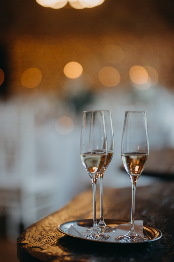 Two glasses of champagne on the table on blurred background. Wedding, party, celebratory toast.