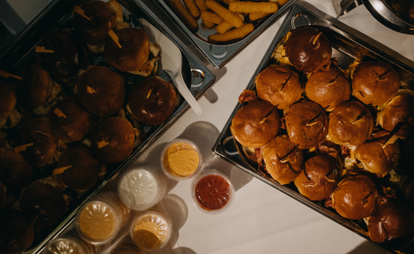 Plate with hamburgers for party, with sides and sauces. Serving hamburgers and fastfood at wedding.