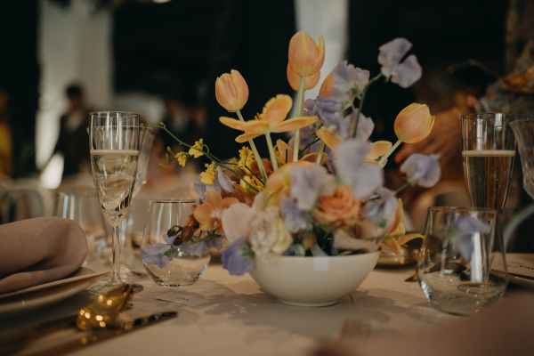 Elegant, romantic table setting for indoor spring wedding reception or party. Luxury wedding table decoration, special event table set up with fresh spring flowers arragements.