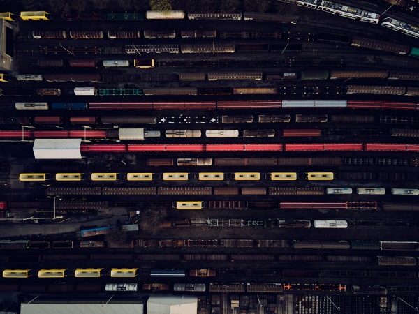 Aerial photo of railway lines, railway junction with trains. Freight wagons with goods on railroad station. Cargo transportation. Import and export logistics in railways. Industrial landscape.