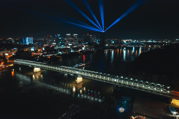 Aerial night shot of Bratislava city, bridges over the Danube river and vibrant nightlife lights in the city center.